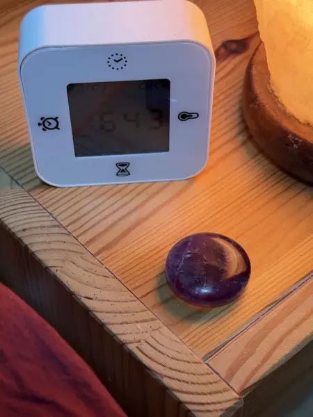 Amethyst on nightstand with alarm clock and salt lamp