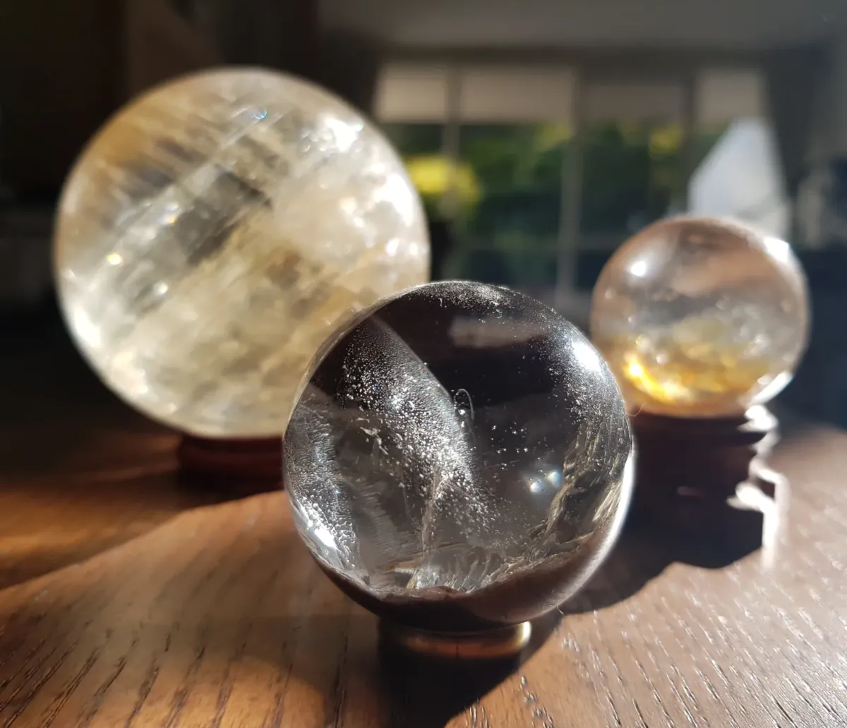 Three clear quartz crystal balls in various sizes.