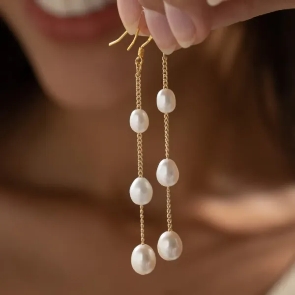 A pair of Freshwater Pearl Drop Earrings - each earring has three pearls connected with golden chain.