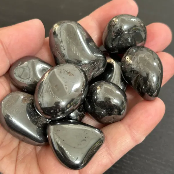 A group of Hematite Tumbled stones on palm of the hand