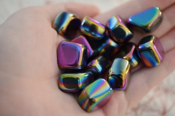 A woman holding many Rainbow Hematite stones