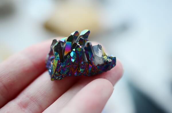 A woman holding a small Titanium Quartz crystal