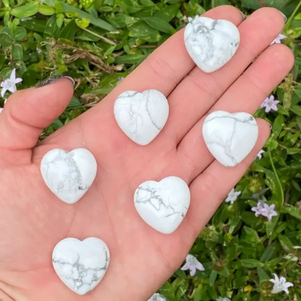 6 pieces of 25mm Howlite Puffy Hearts spread on the palm of the heand