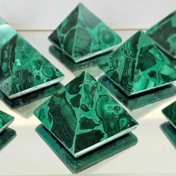 A group of Malachite crystal pyramids on mirroring surface