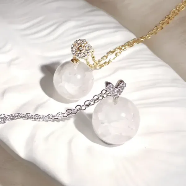 Two pieces of Milky Quartz Chips in a resin sphere pendants on silver and golden chains