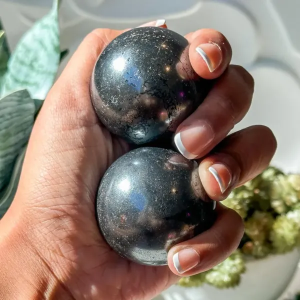 Two Polished Hematite Spheres being hold in the hand