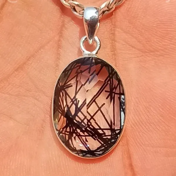 Rutilated Quartz Pendant on the skin background
