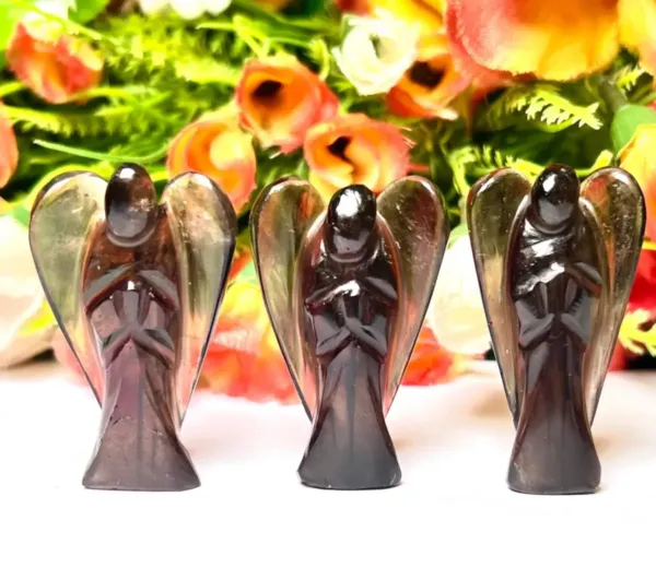 Three Smoky Quartz Guardian Angels in front of flower background.