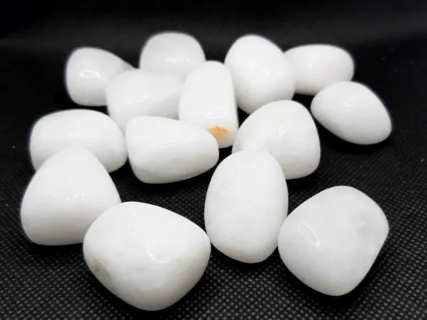 A group of White Onyx Polished Tumbled Stones on black background